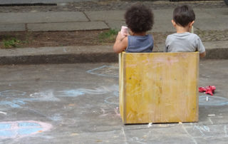 Kita-Fest: Kinder sitzen im Holzkasten