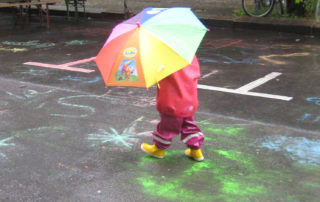 Kita-Fest: Kind unter Regenschirm